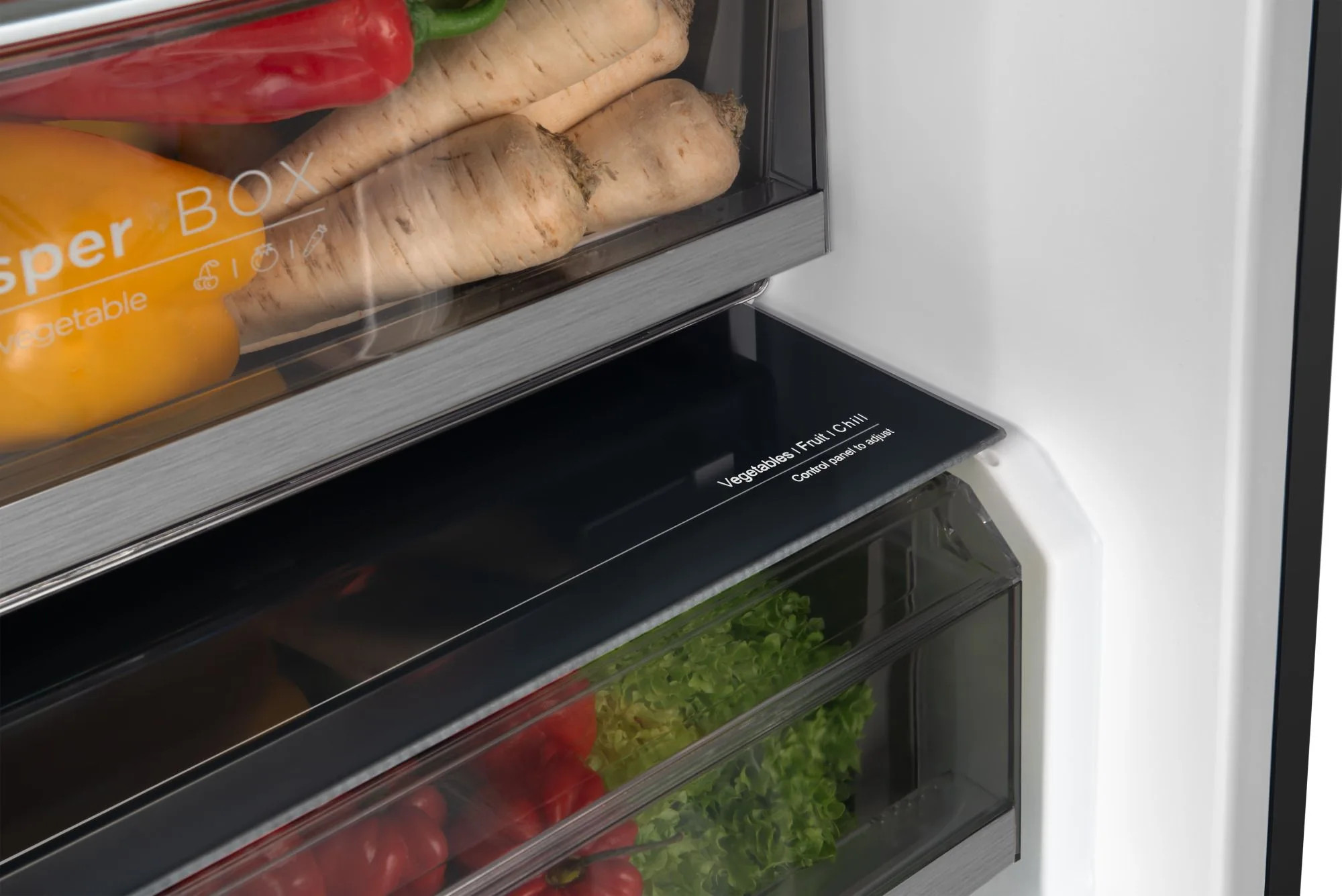 Wnętrze lodówki z warzywami. Pokazuje szufladę z marchewką, papryką i sałatą. Jest panel sterowania do regulacji temperatury.