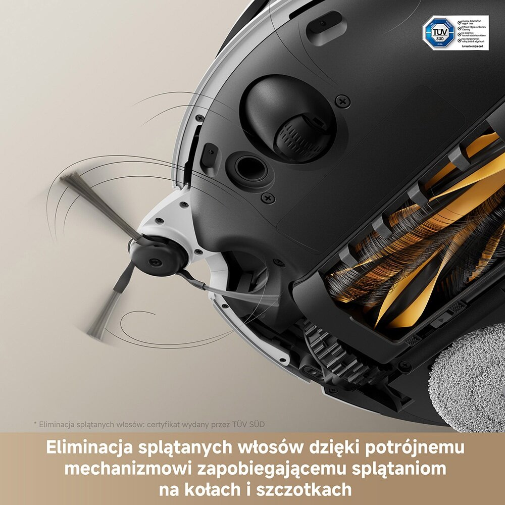 Zbliżenie robota odkurzającego. Ma obrotową szczotkę, czarno-biały korpus i żółtą szczotkę w środku. Widoczne jest logo TÜV SUD.
