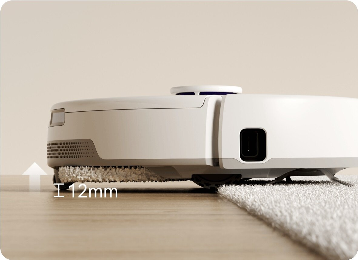 Biały robot odkurzacz na drewnianej podłodze. Jest 12 mm nad podłogą. Po prawej stronie biały dywan.