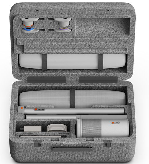 Otwarta szara walizka ujawnia uporządkowane przegródki. Wewnątrz: cylindryczne obiekty, długa rura i różne akcesoria, wszystko schludnie ułożone.