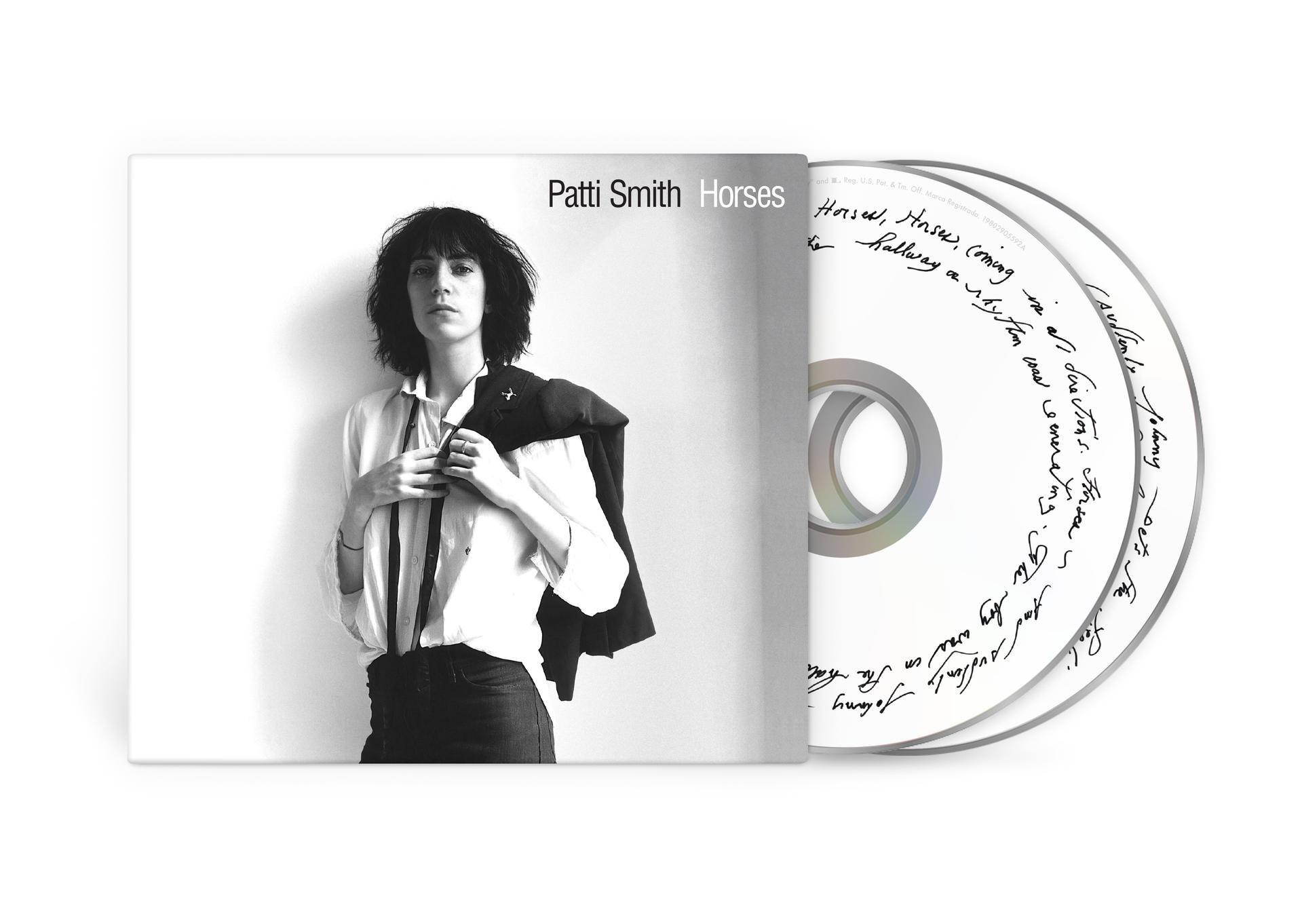 Patti Smith Album 'Horses'. Sie trägt ein weißes Hemd, eine schwarze Jacke und dunkle Hosen. CD-Hülle und CDs sind vorhanden.