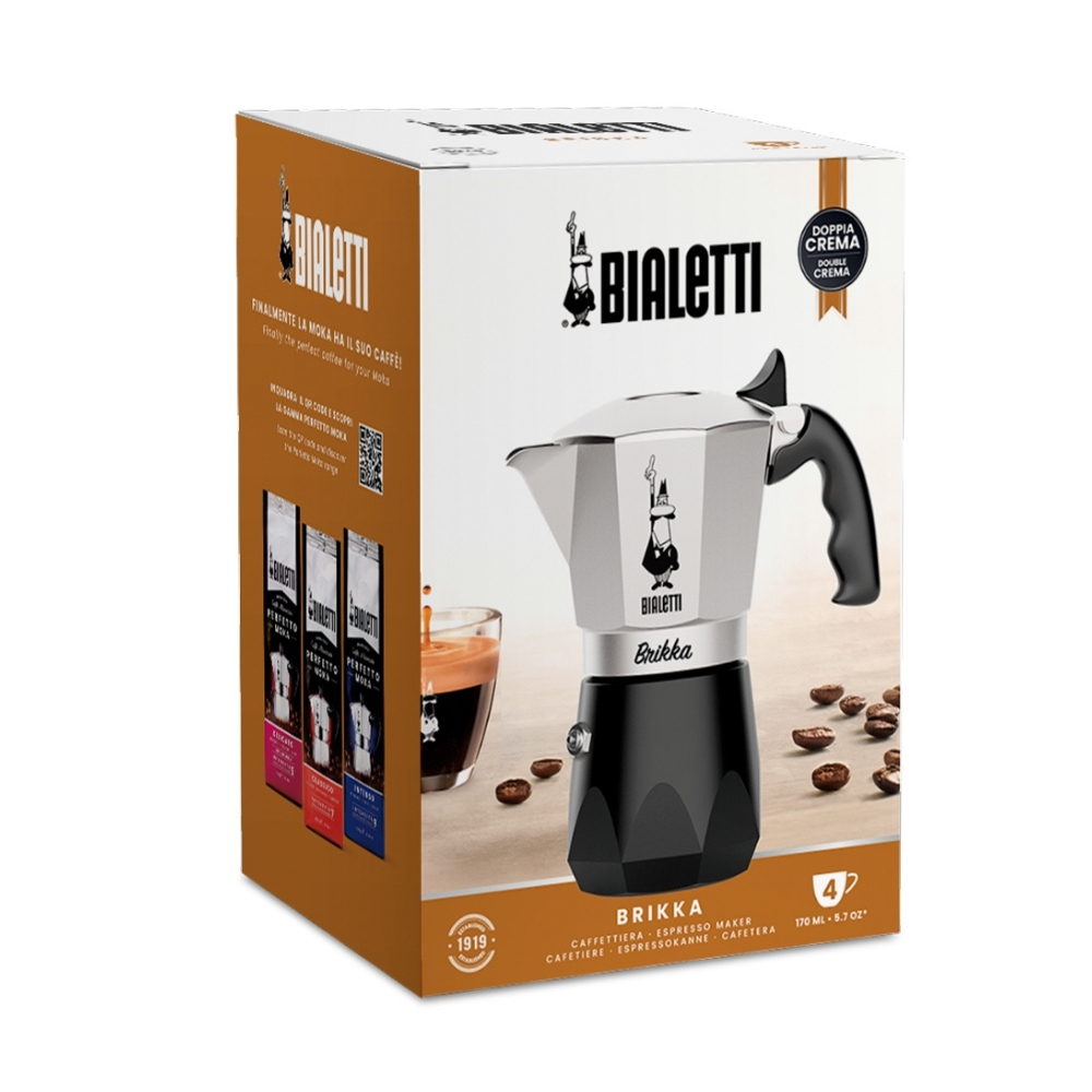 Bialetti Brikka espresso makinesi kutusu. Ürünü, kahve çekirdeklerini, bir bardak kahveyi ve kahve paketlerini gösterir.
