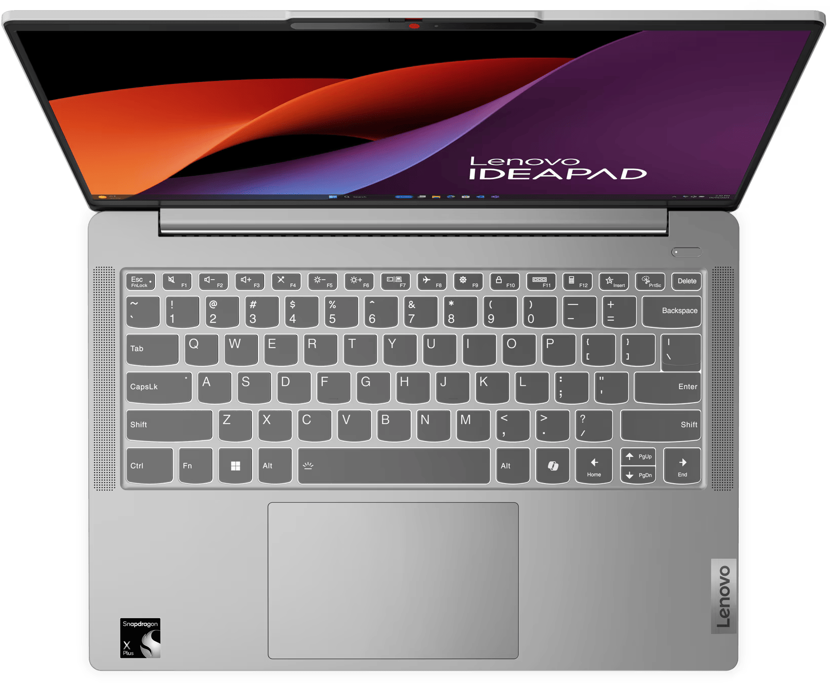 Egy ezüst Lenovo IdeaPad laptop nyitva van. A képernyő színes absztrakt dizájnt mutat. A billentyűzet látható.