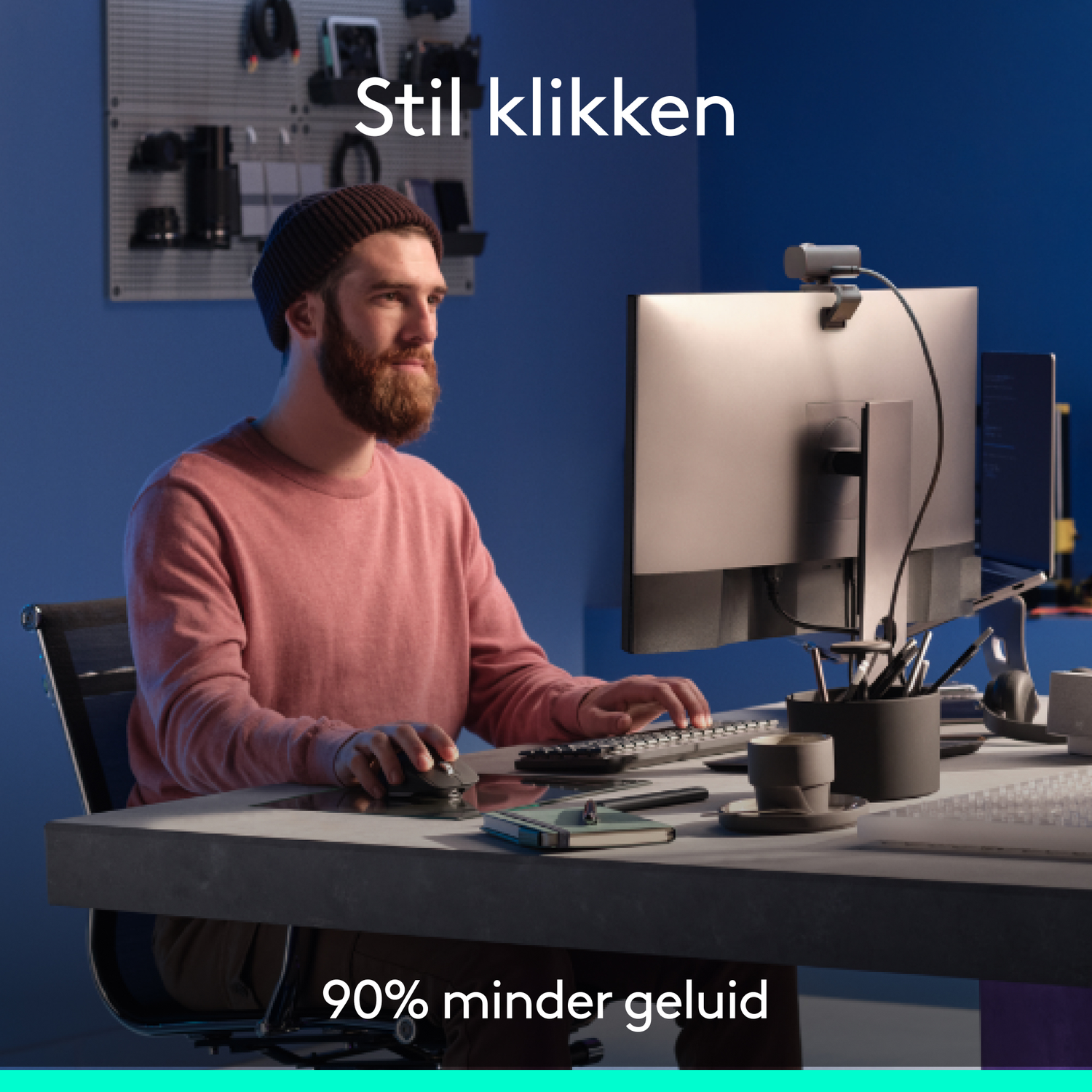 A man with a beard is working on a computer. Text reads 'Stil klikken' and '90% minder geluid'.