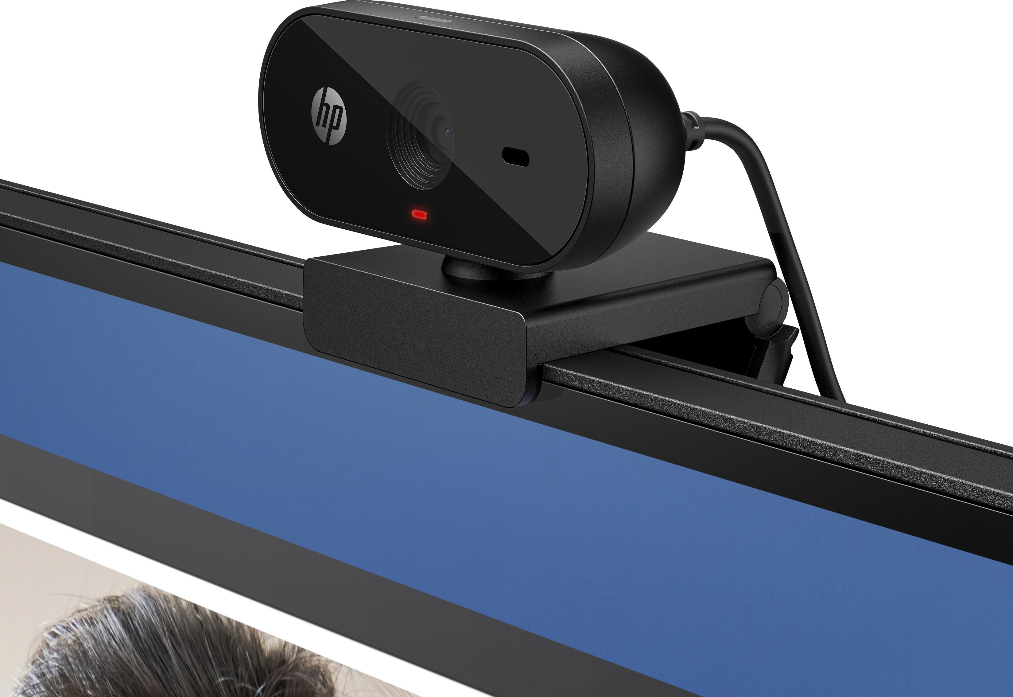 Eine schwarze HP-Webcam ist an einem Monitor befestigt. Sie hat eine ovale Form, ein rotes Licht und ein Kabel. Der Monitor ist schwarz und blau.