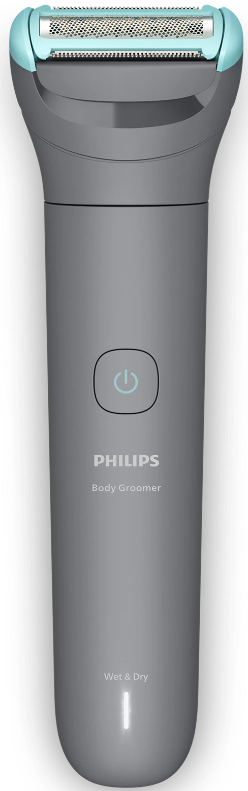 Ein Philips Body Groomer, grau und blaugrün, vor schwarzem Hintergrund. Der Rasierer hat einen Einschaltknopf und den Text 'Wet & Dry'.