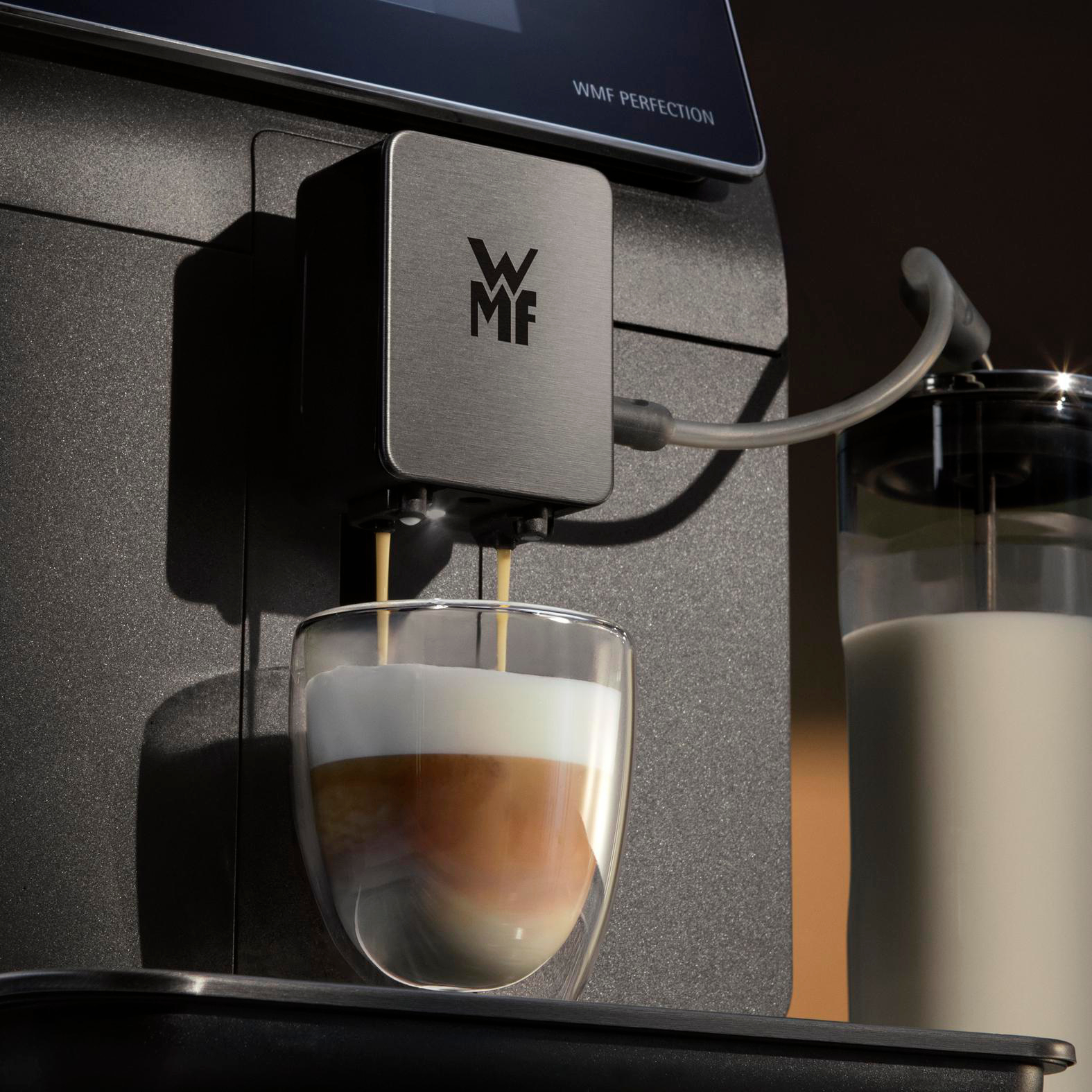 Kaffeemaschine, die Kaffee in ein Glas ausgibt. Schichten aus Schaum und Kaffee. Milchbehälter rechts.