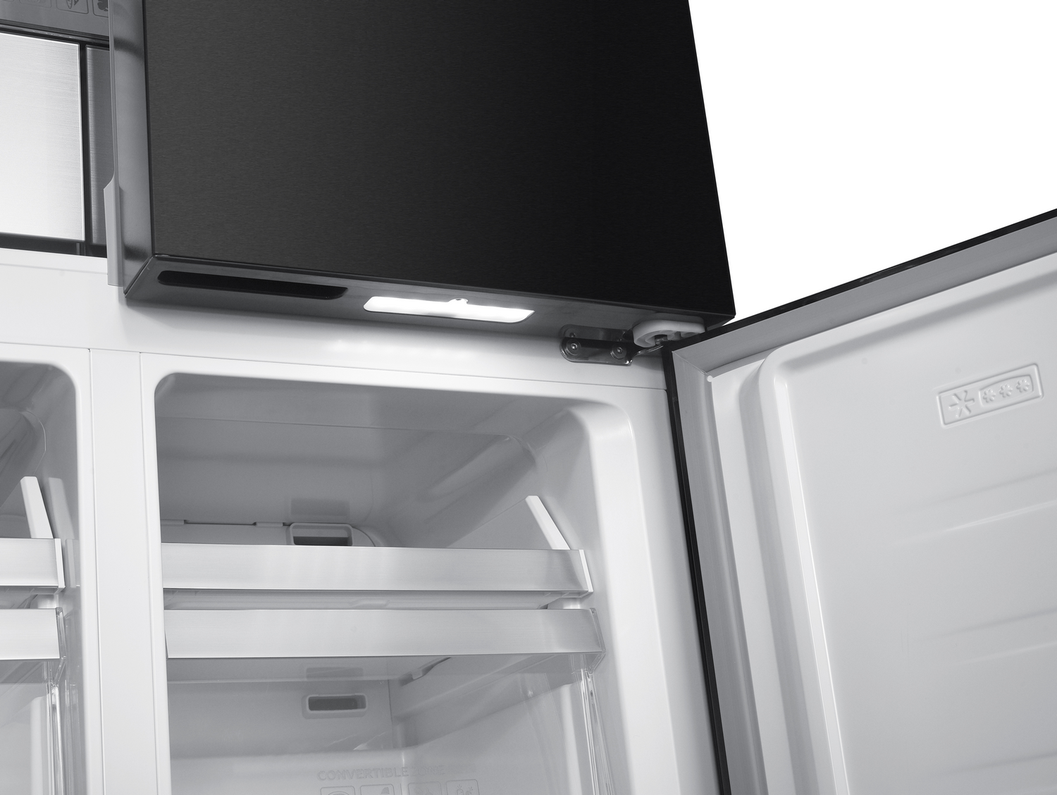 Primer plano de un refrigerador abierto. Parte superior negra, interior blanco con estantes y puerta abierta. Luz brillante ilumina el interior.