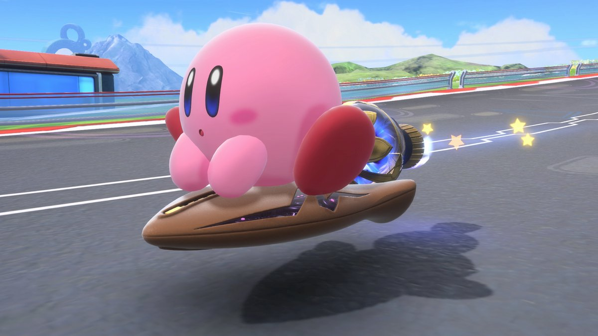 Kirby on a brown hoverboard, with a blue and gold engine. The background shows a race track, mountains, and a blue sky.