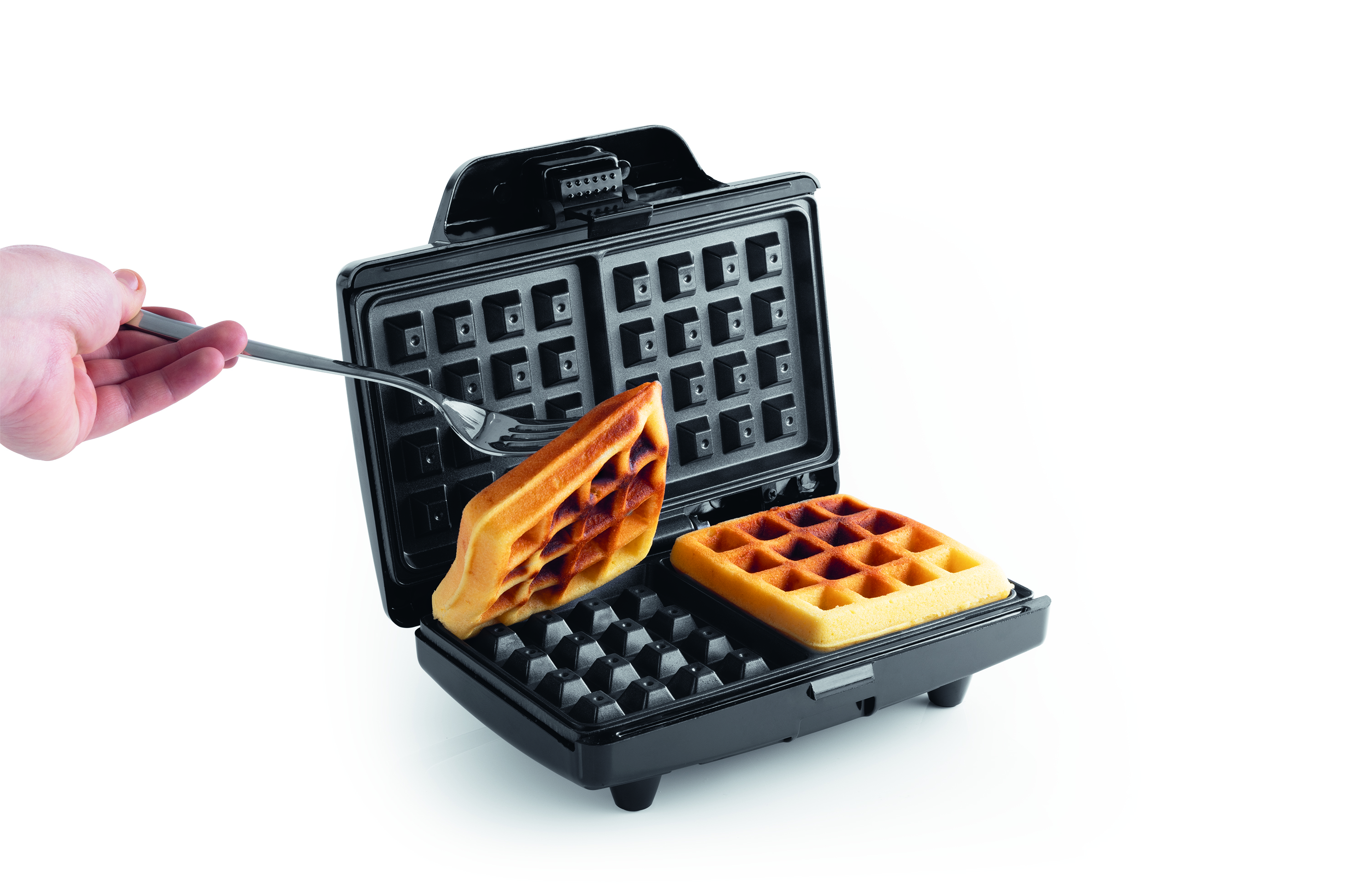 Ein Waffeleisen mit zwei Waffeln. Eine Hand hält eine Gabel und hebt eine Waffel heraus. Die Waffeln sind goldbraun.
