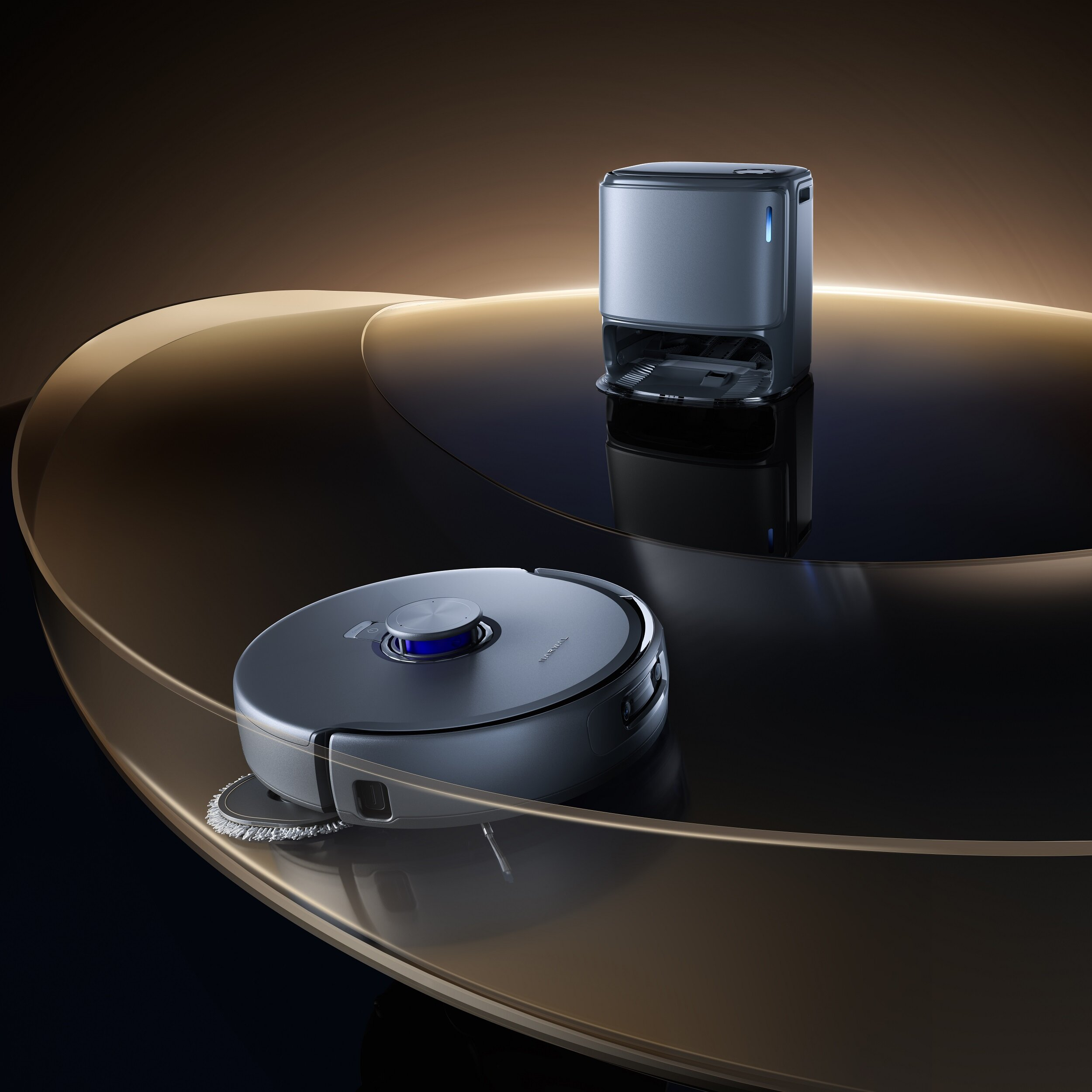 Robot odkurzający i jego stacja ładująca na odblaskowej powierzchni, z rozmytym tłem.