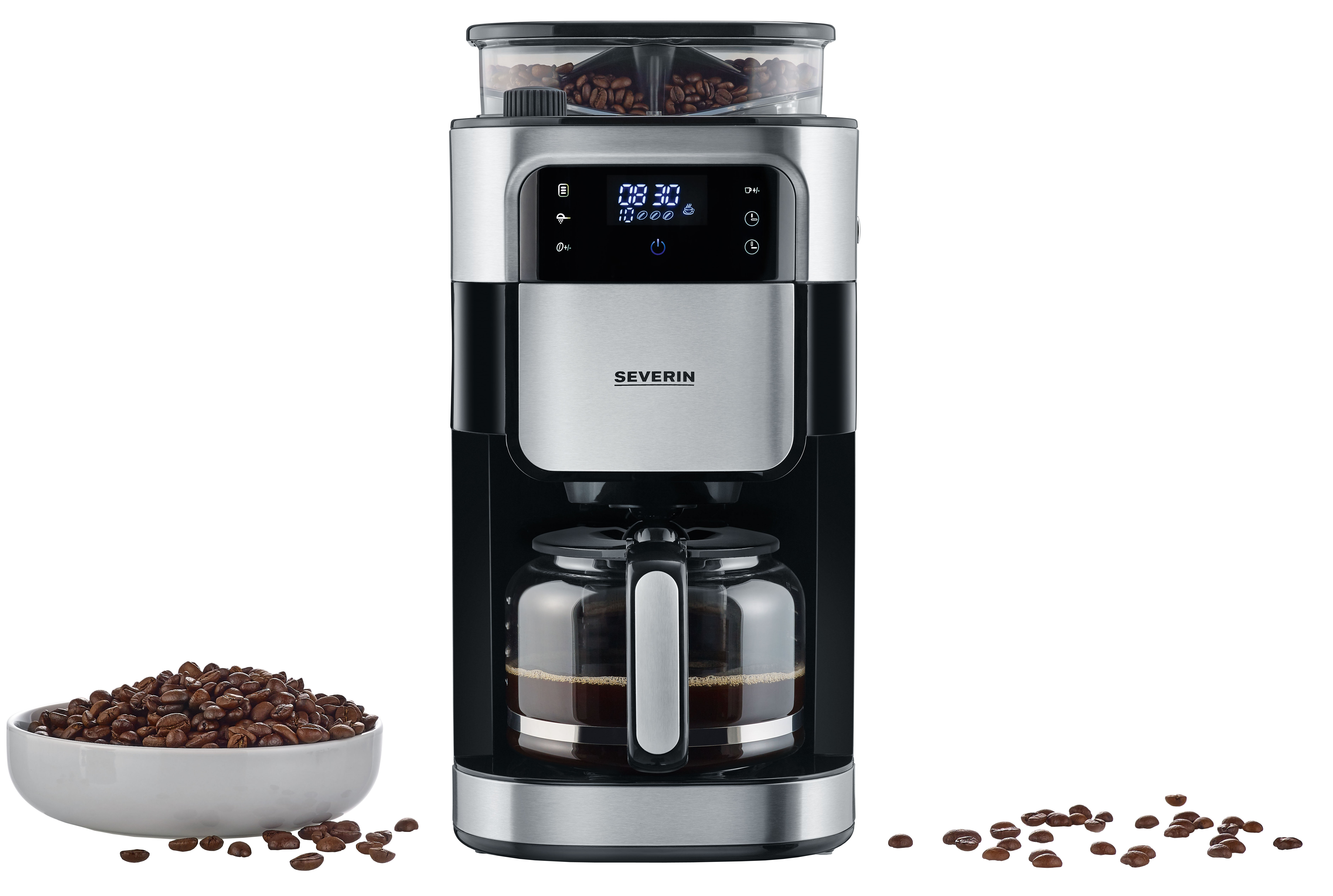 Ekspres do kawy z młynkiem do ziaren, szklaną karafką i miską ziaren kawy, z rozrzuconymi ziarnami.