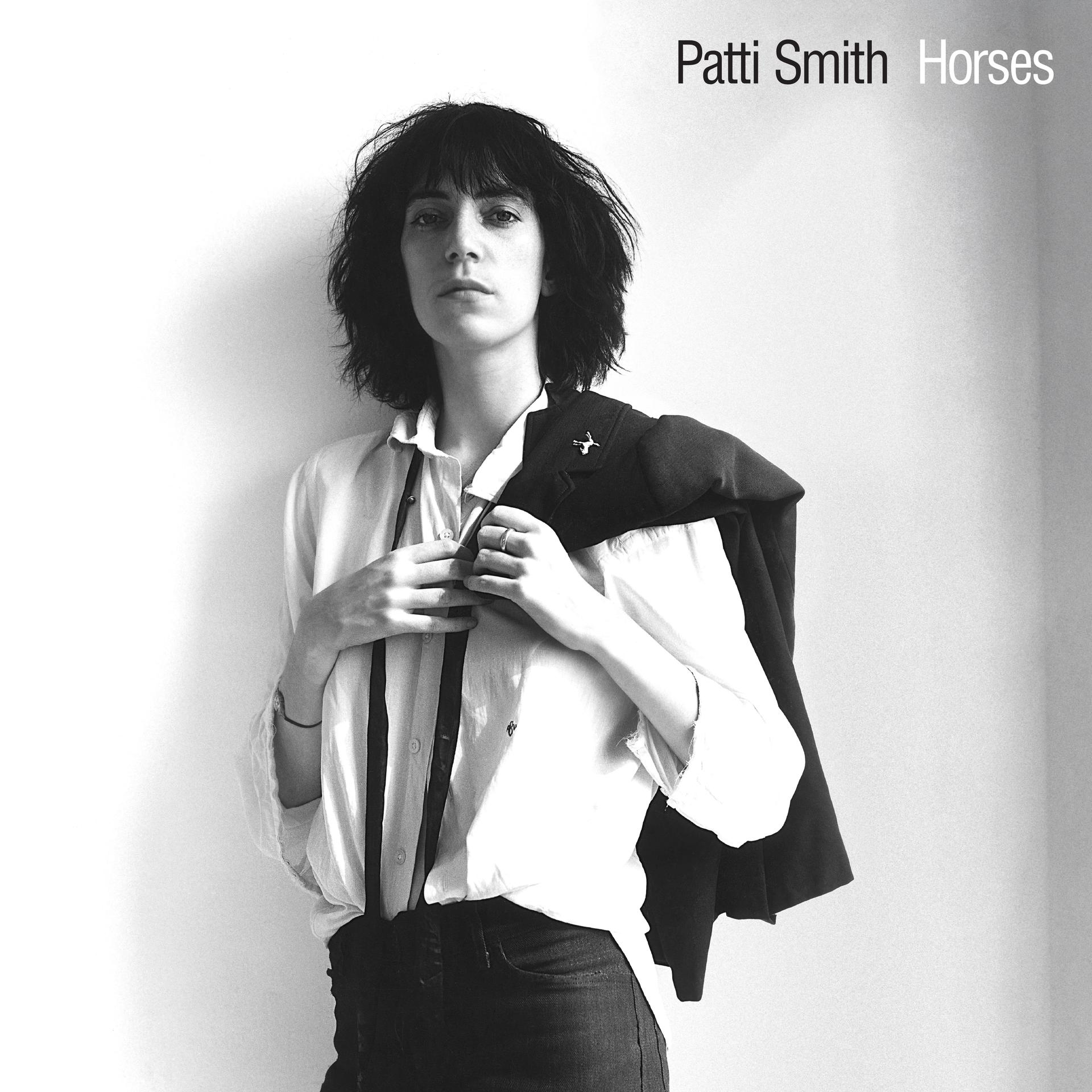 Patti Smith, Schwarz-Weiß-Porträt. Sie trägt ein weißes Hemd, eine schwarze Jacke über der Schulter und dunkle Hosen. Albumcover.