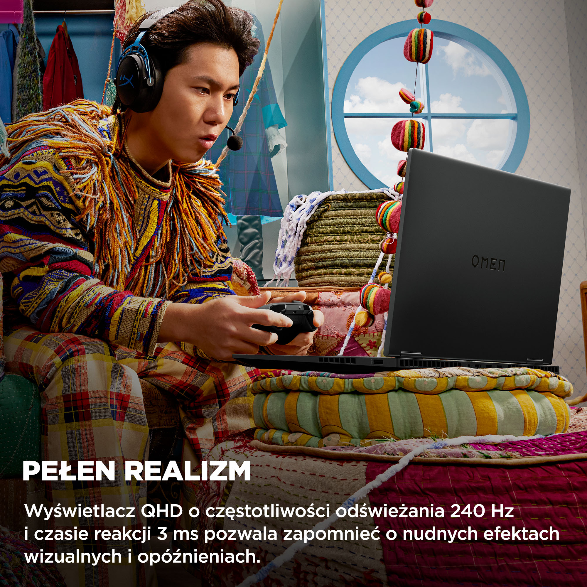 Osoba w słuchawkach gra na laptopie. Laptop jest na kolorowej poduszce. Tło obejmuje okno i ubrania.