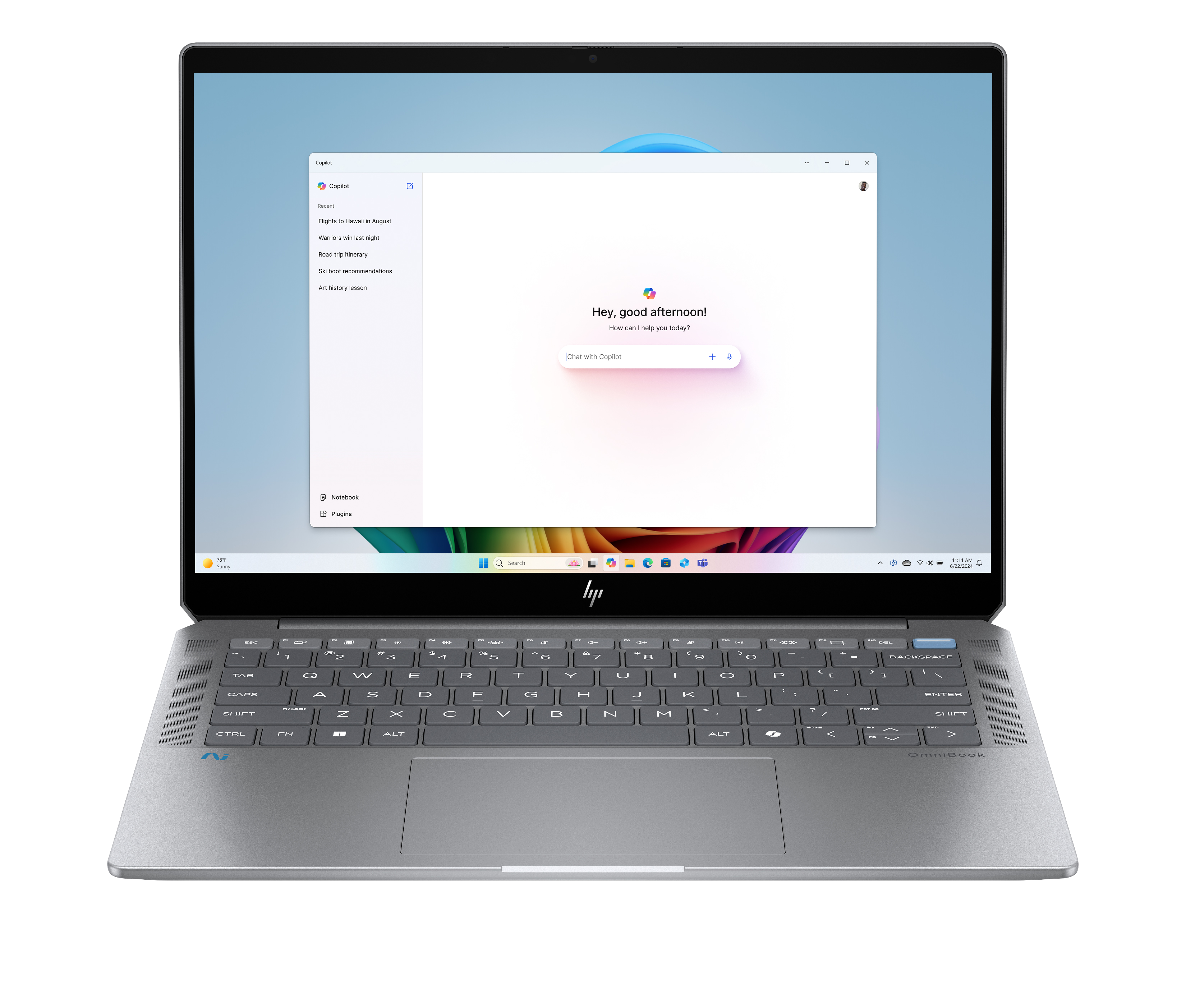 Laptop jest otwarty, pokazując okno czatu Copilot. Klawiatura jest widoczna poniżej. Ekran wyświetla niebieskie tło.