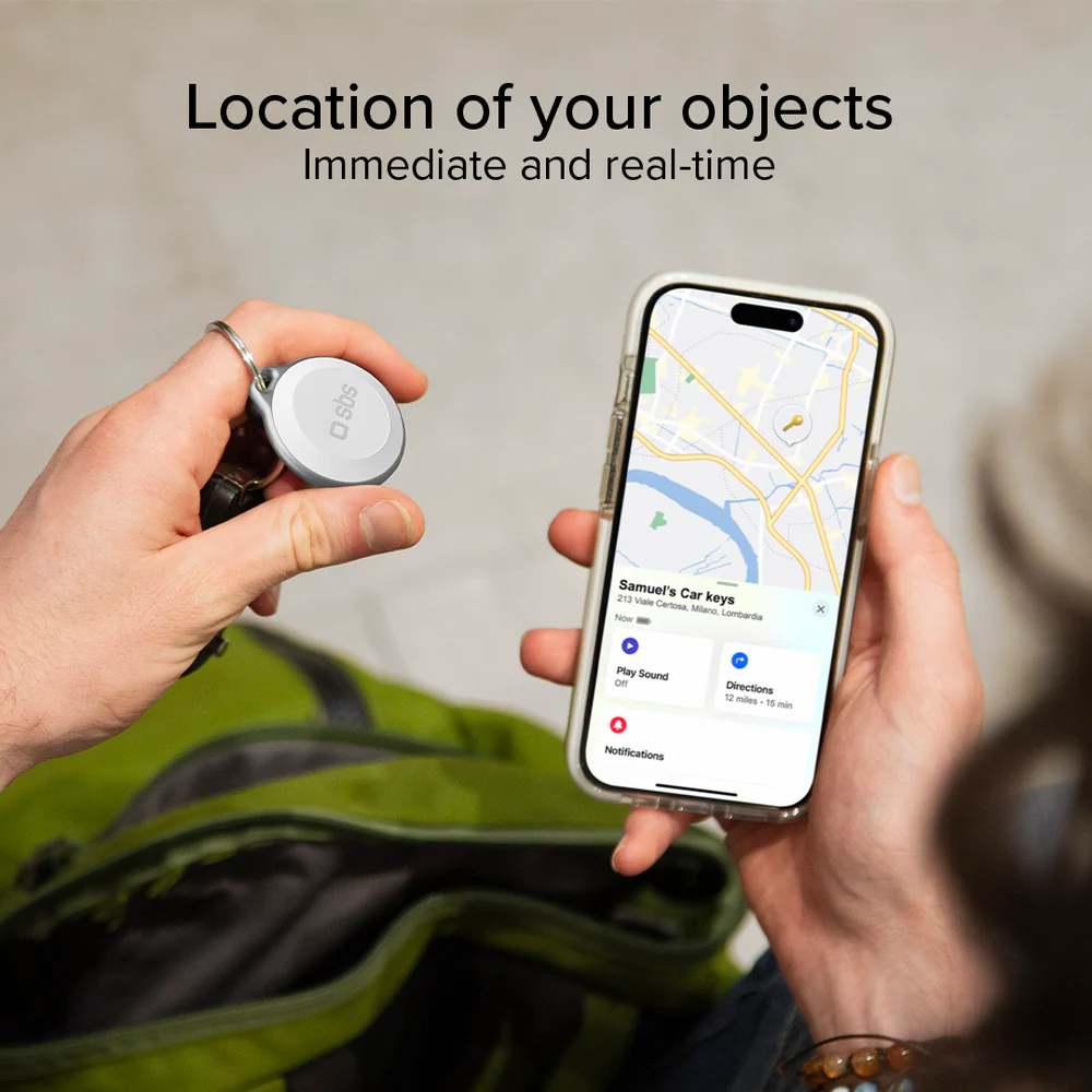 Hände halten einen Schlüssel-Tracker und ein Telefon mit einer Karte. Das Telefon zeigt den Standort von Autoschlüsseln.
