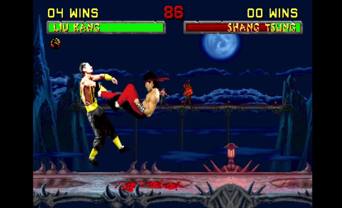 Mortal Kombat-Szene. Liu Kang tritt Shang Tsung. Anzeigetafeln zeigen Siege. Charaktere sind in Aktion. Der Hintergrund ist eine Nachtszene.