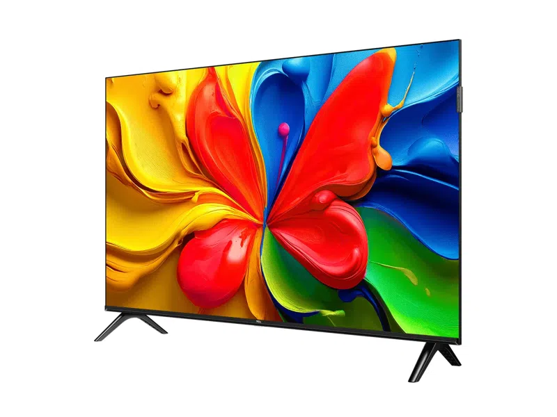 Egy TCL TV színes absztrakt képpel a képernyőn, piros, sárga, kék és zöld festékszerű örvényekkel. Fekete lábak tartják a TV-t.