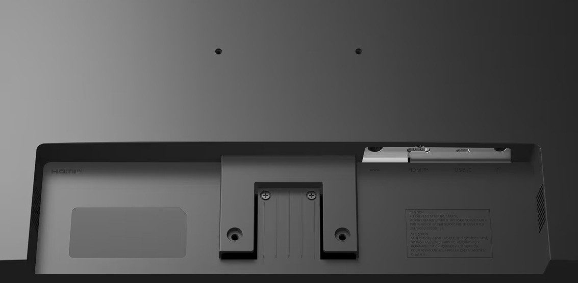 Widok z tyłu monitora z portami, wspornikiem montażowym i dwoma otworami na śruby. Widoczne porty HDMI i USB-C.