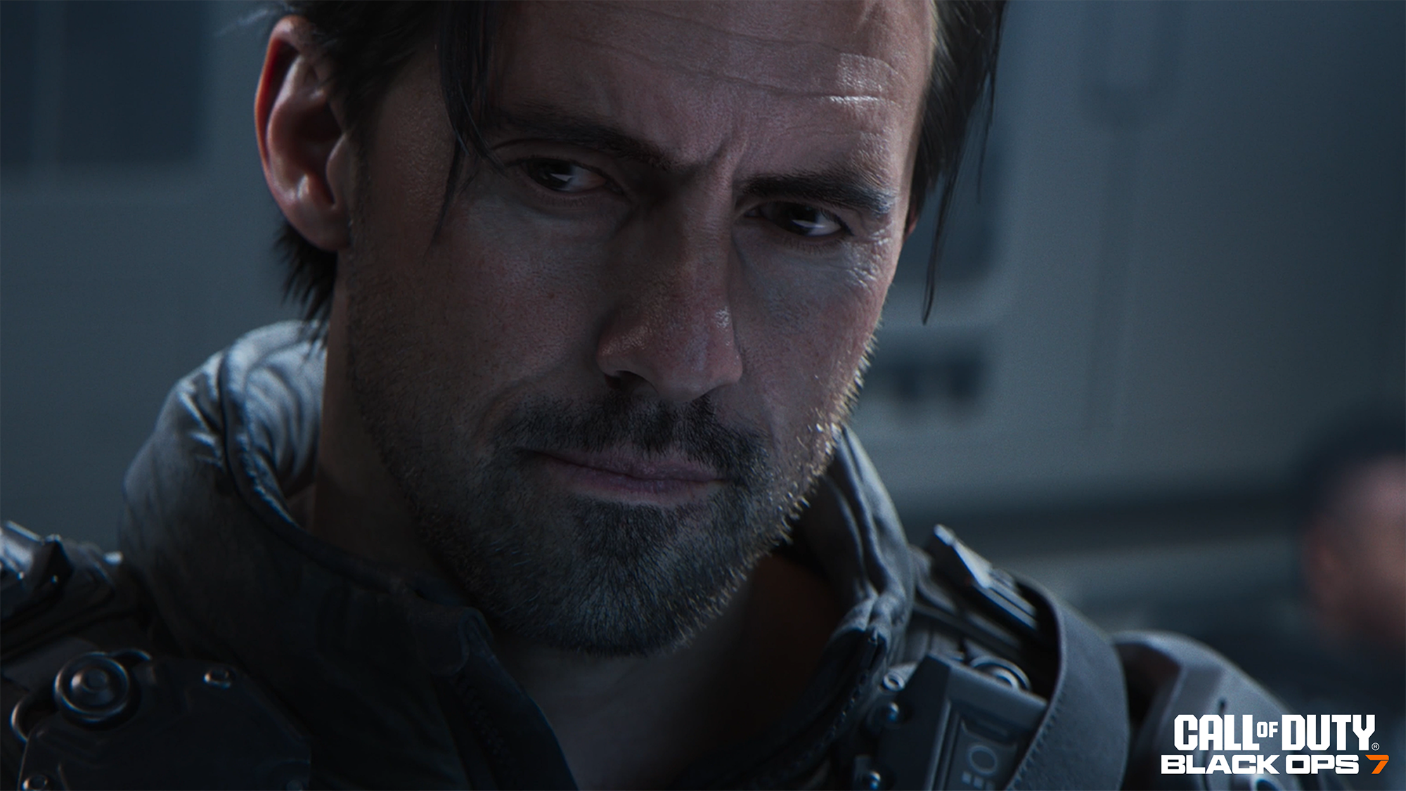 Gros plan d'un homme aux cheveux et barbe sombres, portant une veste sombre. Le logo Call of Duty Black Ops 7 est dans le coin.