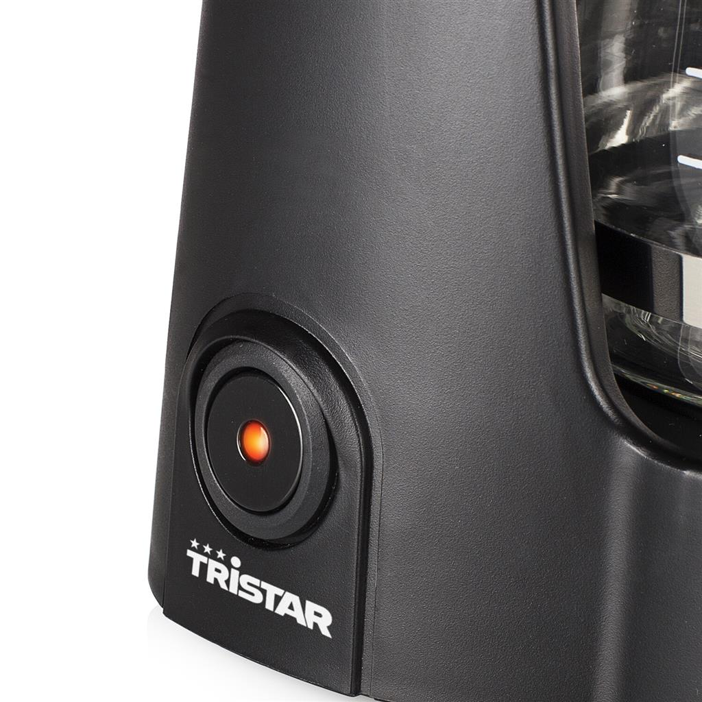 Primo piano di una macchina da caffè nera con pulsante di accensione rosso illuminato. Il logo Tristar è visibile.