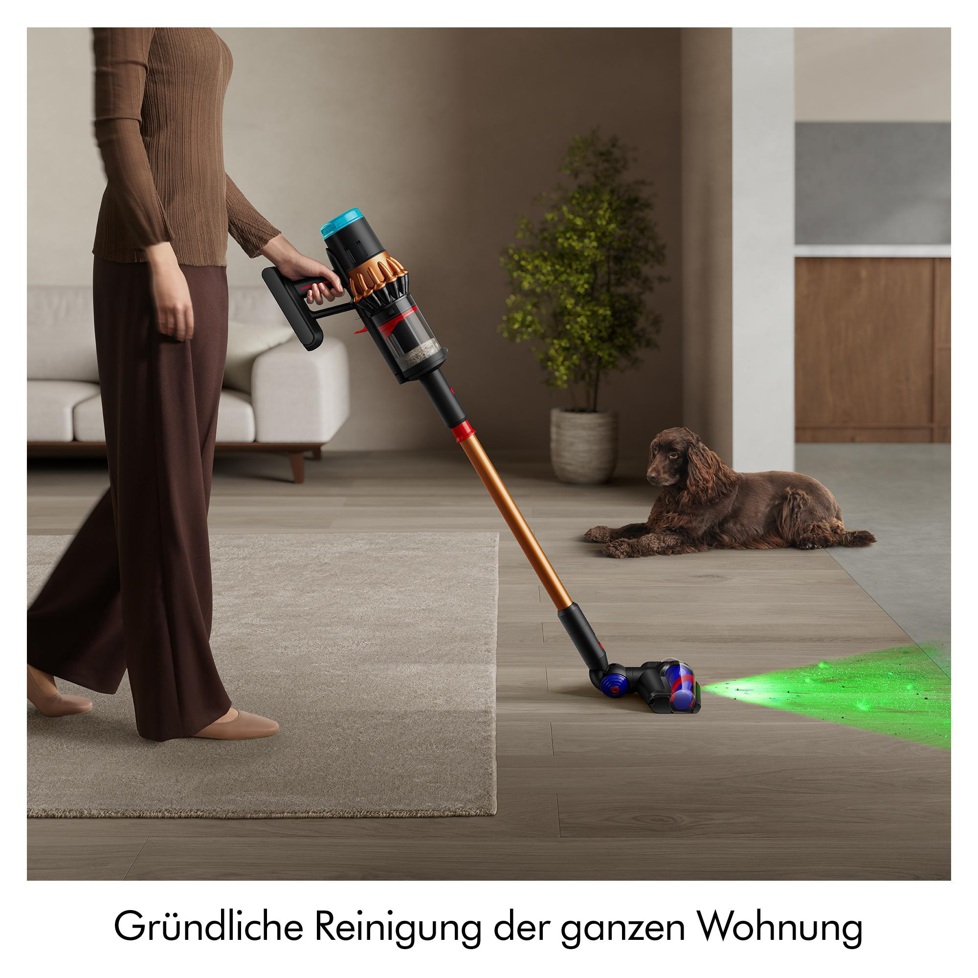 Eine Frau saugt mit einem kabellosen Staubsauger einen Raum. Ein Hund liegt auf dem Boden. Der Boden zeigt grünes Licht.