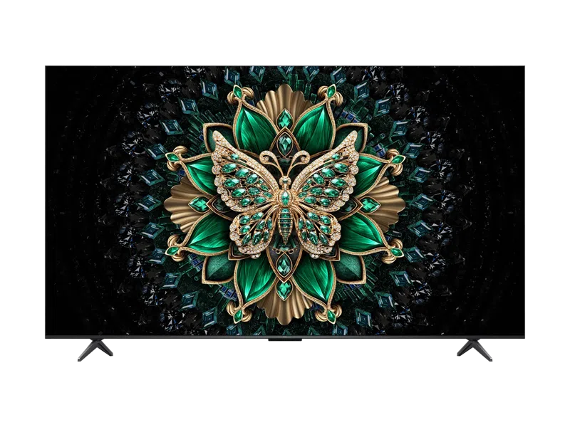 Ein Fernseher zeigt ein geschmücktes Schmetterlings- und Blumendesign. Der Schmetterling ist grün und gold mit Edelsteinen. Der Hintergrund ist schwarz mit Edelsteinen.