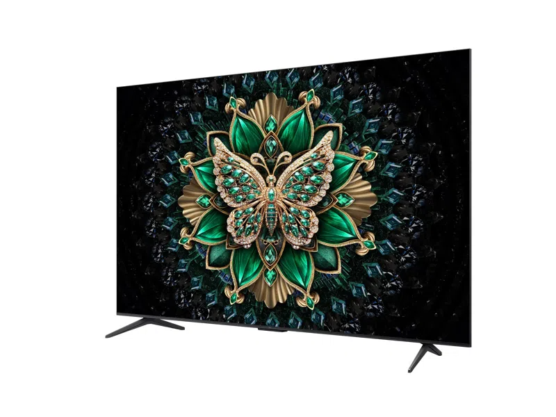 Ein großer Fernseher zeigt einen mit Juwelen besetzten Schmetterling. Der Hintergrund ist schwarz mit Diamanten. Der Schmetterling ist grün, gold und verkrustet.