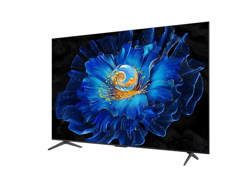 Egy modern TV egy kék virágot jelenít meg arany spirál középponttal, fekete háttér előtt. A TV fehér felületen van.