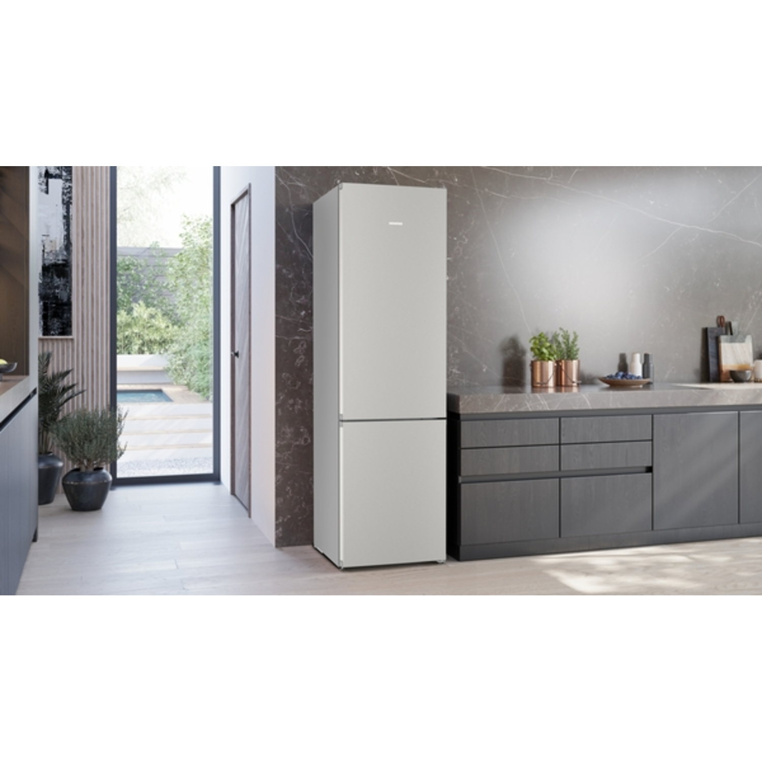 Een moderne keuken met een zilveren koelkast. Donkere kasten en een marmeren aanrecht. Een deur leidt naar een tuin.