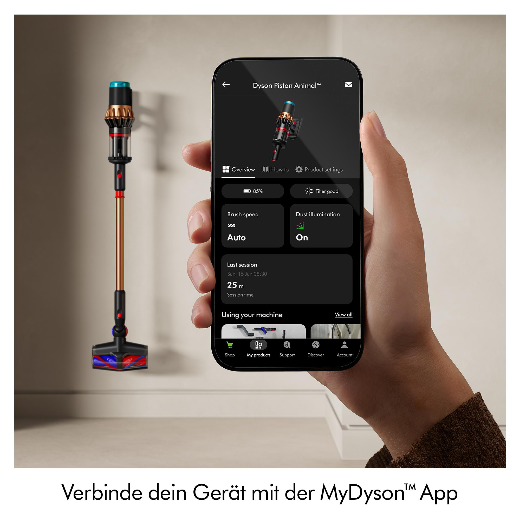 Eine Hand hält ein Telefon, das die Dyson-App-Oberfläche anzeigt, mit einem Staubsauger links. Der Text lautet 'Verbinde dein Gerät mit der MyDyson™ App'.