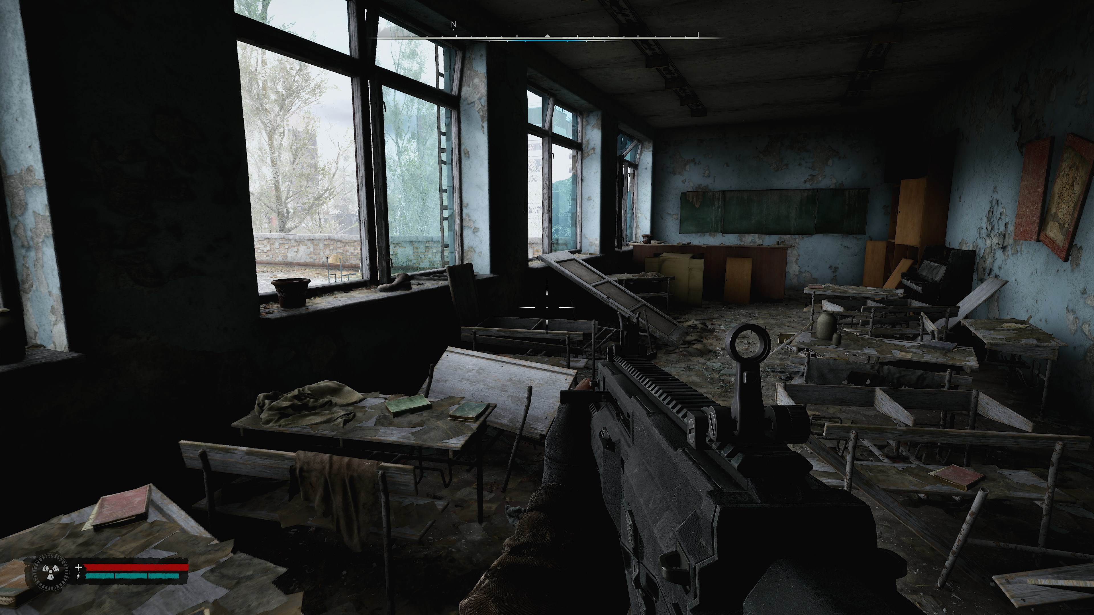 Une prise de vue intérieure montre une salle de classe détruite. Une arme est tenue au premier plan. Des bureaux et des fenêtres sont visibles. La pièce est sombre et endommagée.