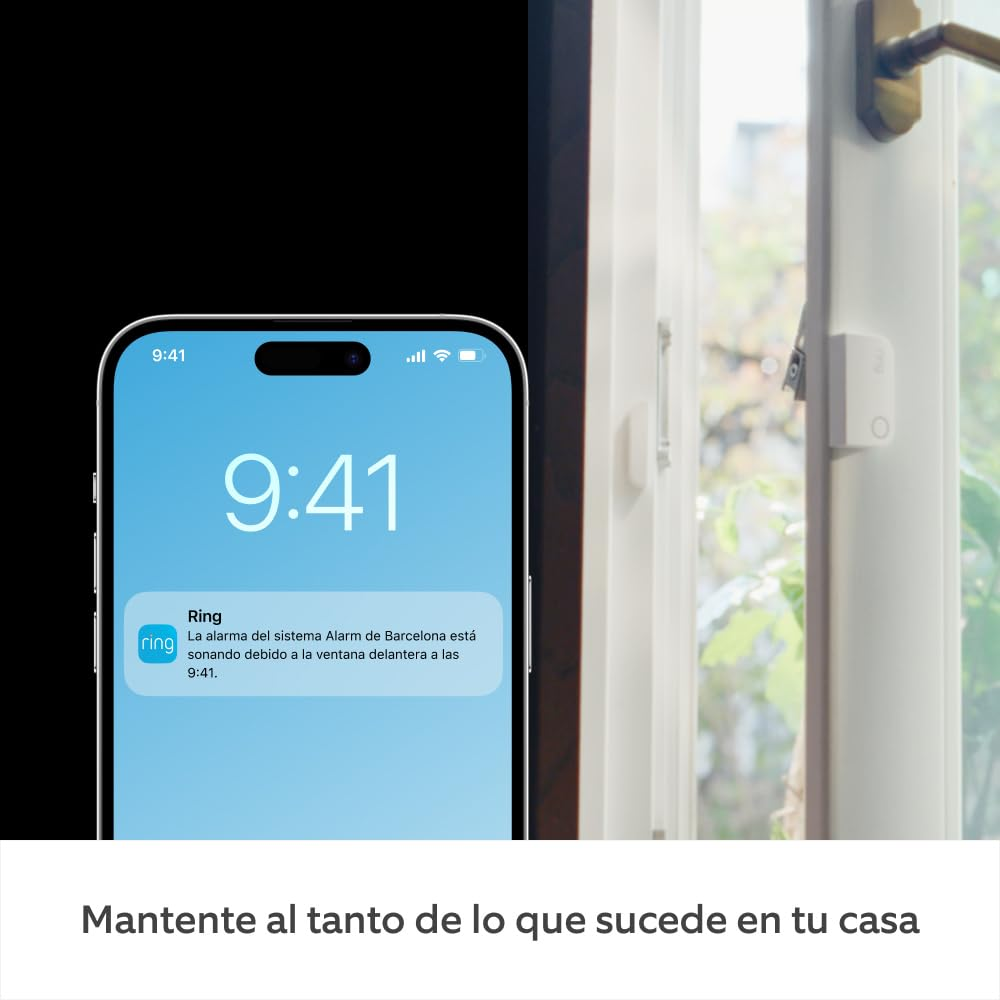 Un teléfono muestra una notificación de Ring sobre una alarma. Se ve una ventana con sensor, con luz del exterior brillando.