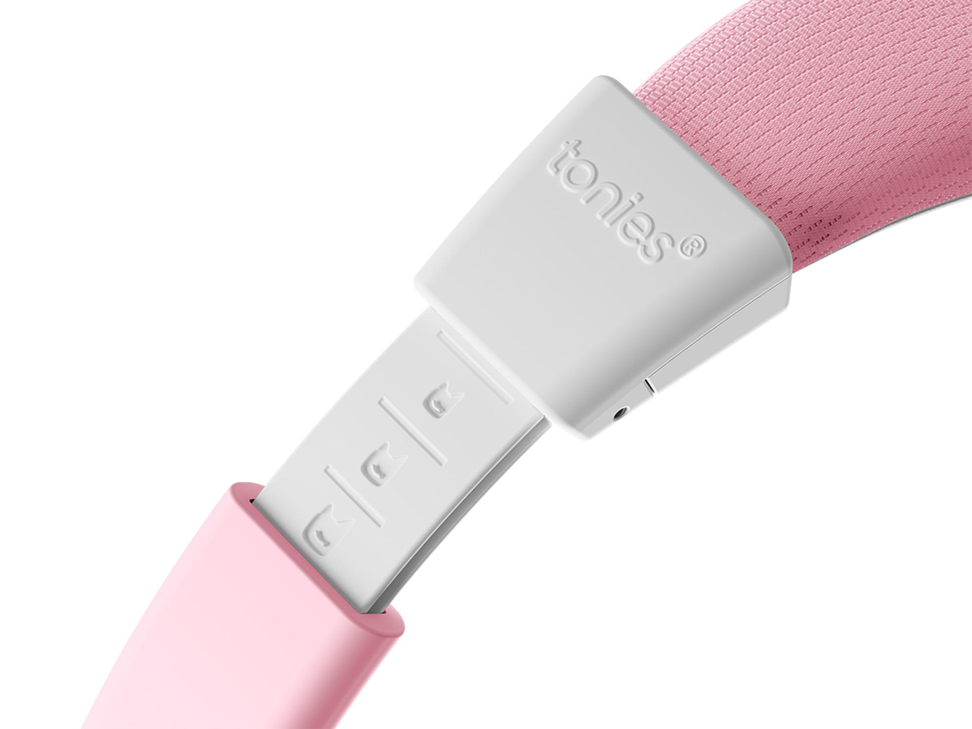 Ein weißes und rosa Tonies-Gerät. Der weiße Teil hat den Markennamen. Ein rosa Gurt ist sichtbar. Das Gerät ist vor weißem Hintergrund.