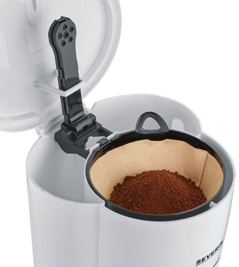 Biały ekspres do kawy z czarnym uchwytem. Papierowy filtr jest wypełniony brązową kawą mieloną.