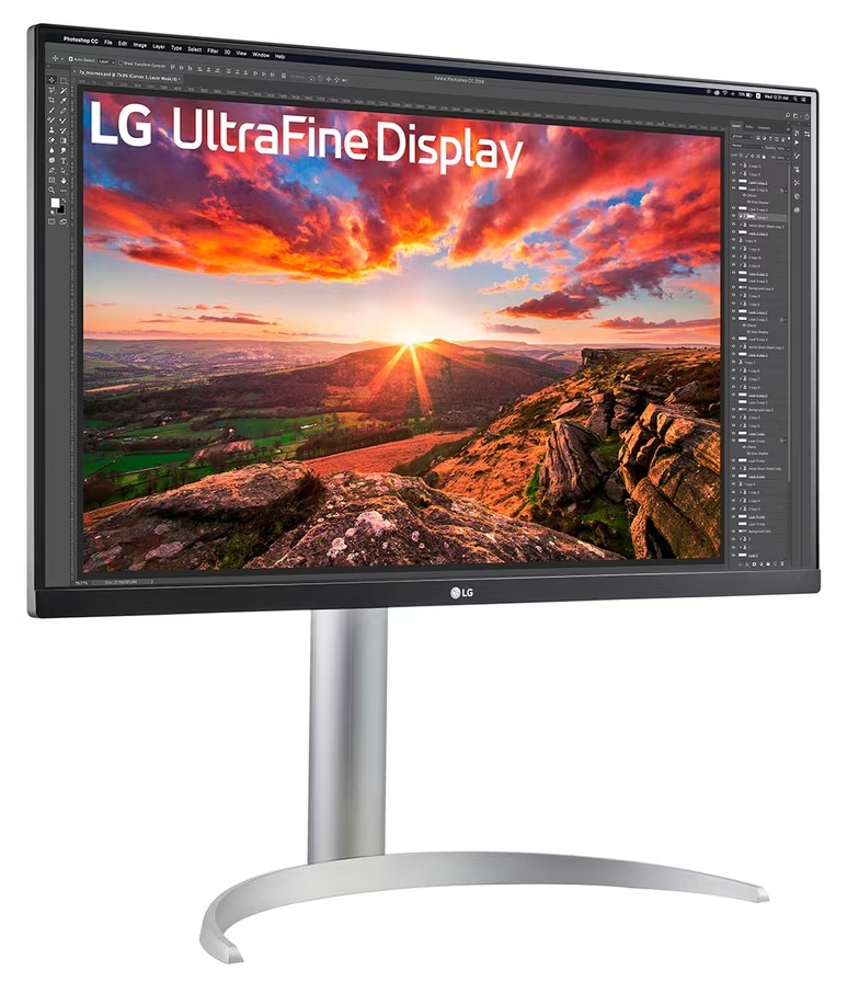 Monitor LG UltraFine Display. Wyświetla krajobraz zachodu słońca z górami i żywym niebem. Monitor ma srebrną podstawę.