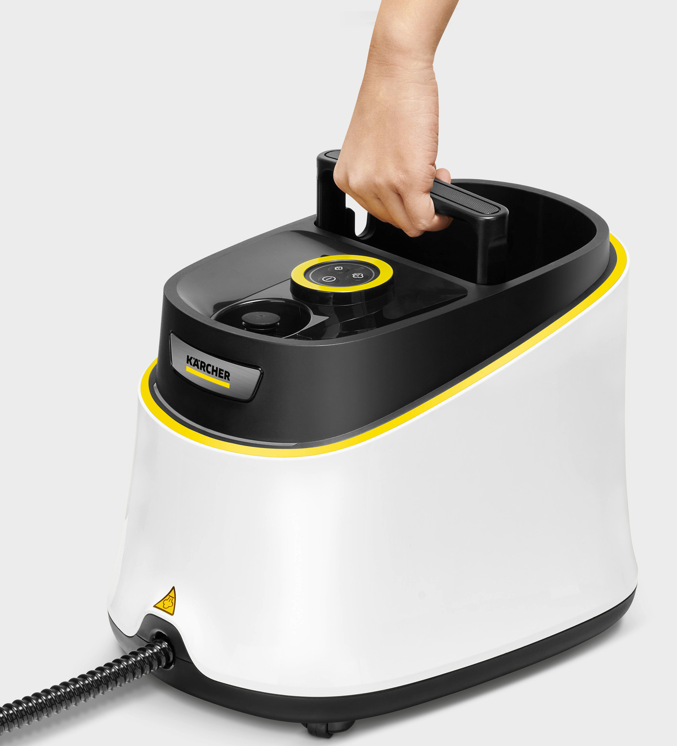 Biało-czarny odkurzacz parowy Kärcher jest trzymany przez rękę. Ma żółte akcenty i czarny wąż. Widoczny jest znak ostrzegawczy.