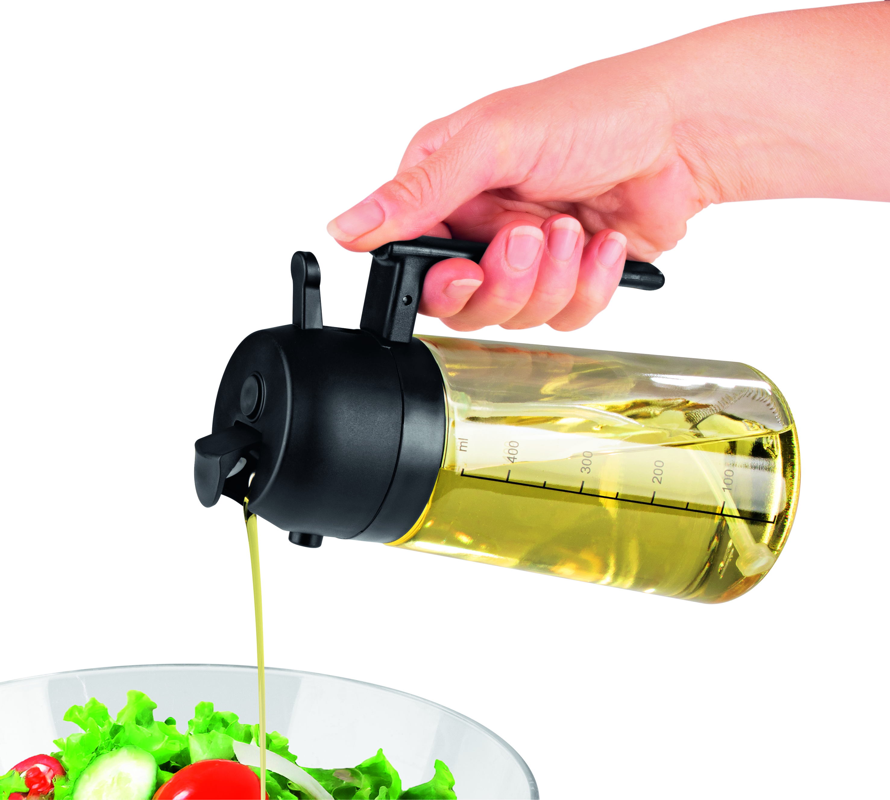 Eine Hand gießt Dressing aus einer klaren Flasche mit schwarzem Deckel auf einen Salat.