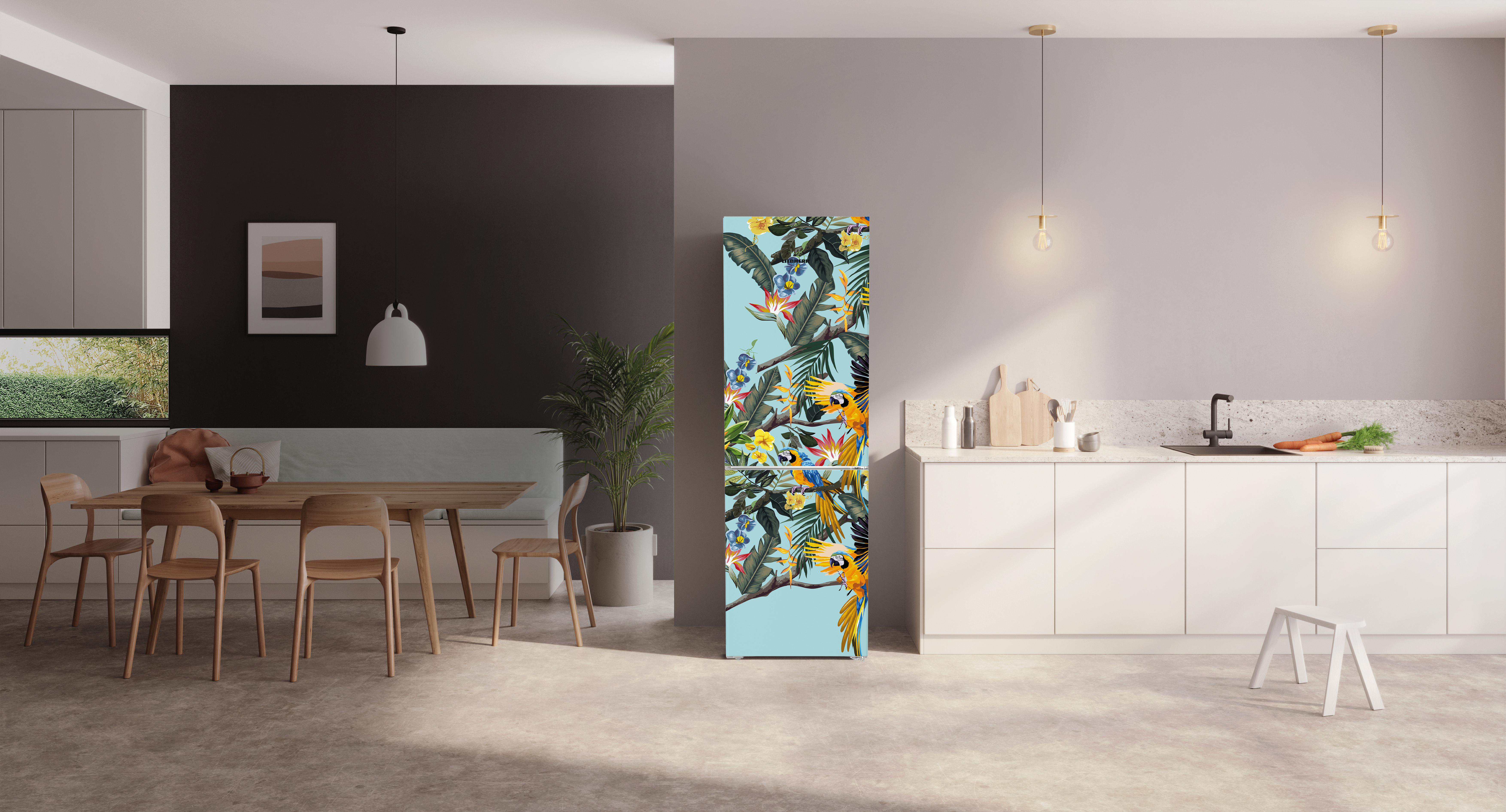 Küche mit floralem Kühlschrank. Esstisch links. Weiße Schränke und ein Waschbecken rechts. Kleiner Hocker vor der Spüle.