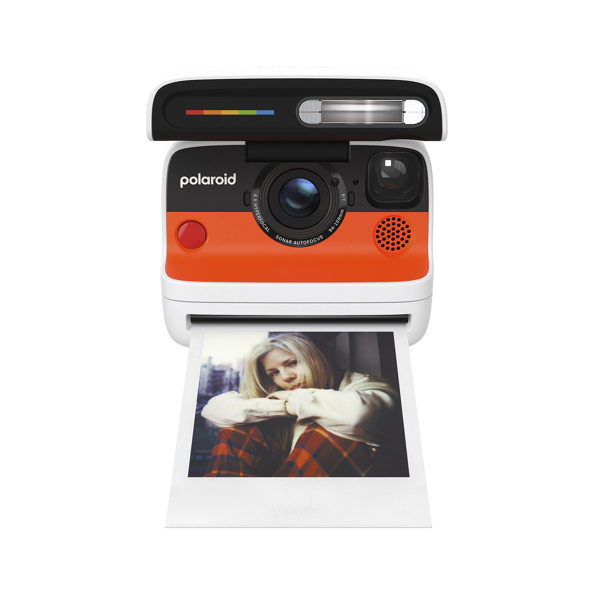 Turuncu ve siyah detaylara sahip Polaroid fotoğraf makinesi, ekose gömlekli bir kadının fotoğrafını basıyor.