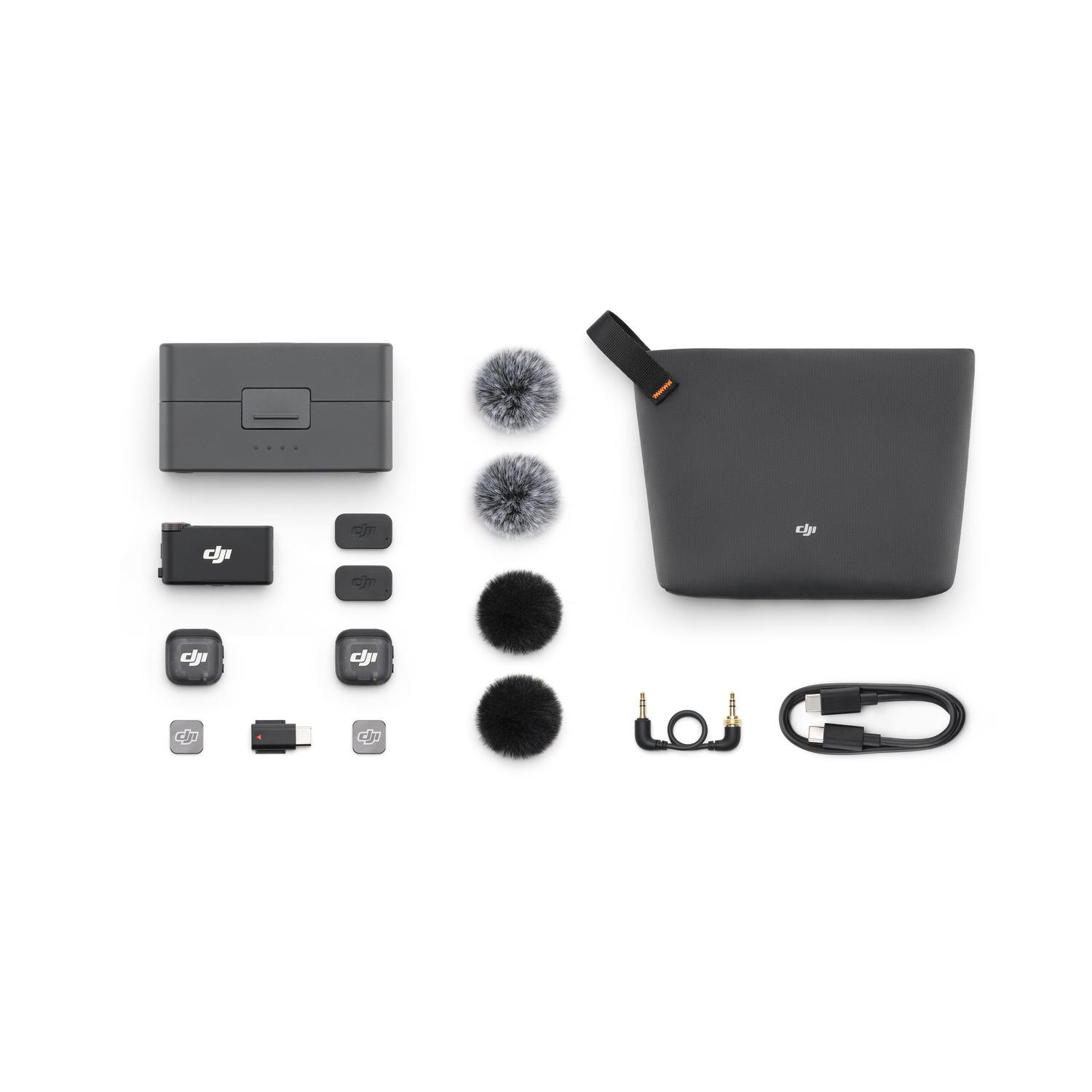 Kit microfono DJI su sfondo bianco. Include custodia di ricarica, microfoni, antivento, custodia, cavi e adattatori.