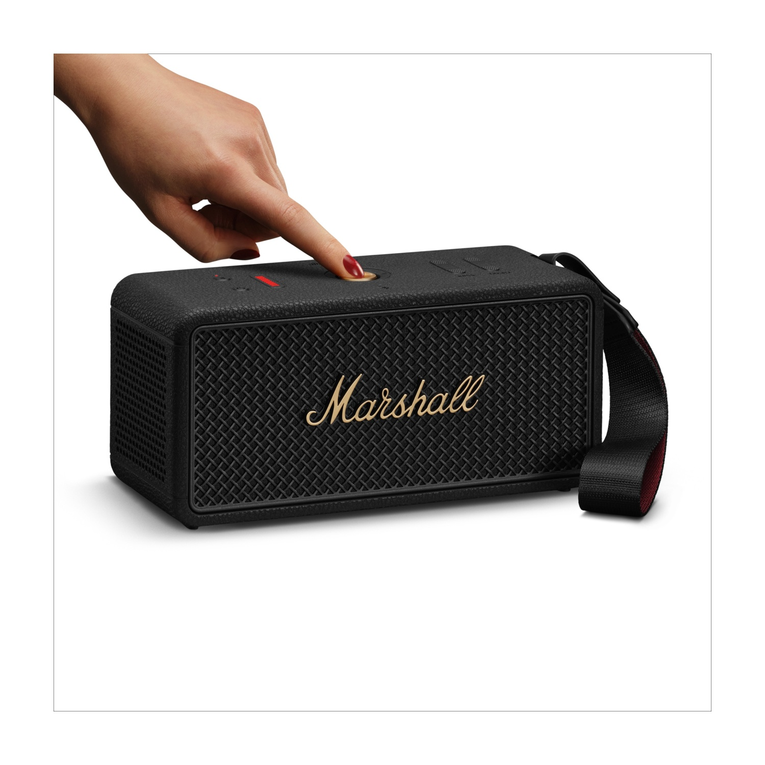 Una mano preme un pulsante su un altoparlante Marshall nero. L'altoparlante ha una cinghia. Lo sfondo è bianco.