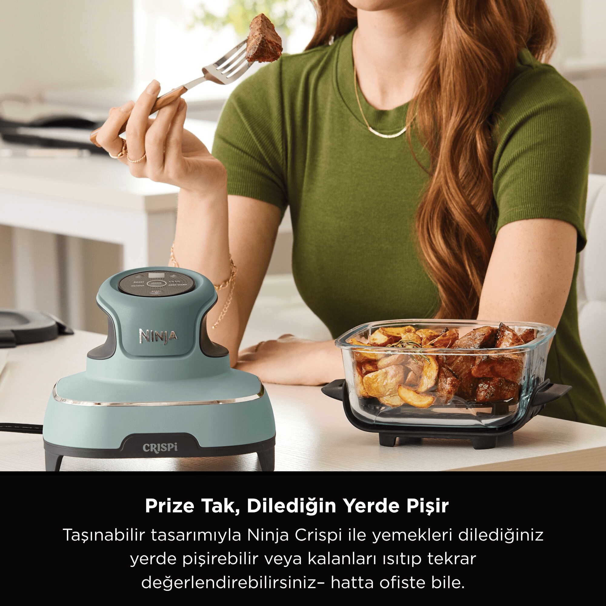 Bir kadın, çatalında et tutuyor. Masada bir Ninja Crispi cihazı ve bir tabak yemek var.