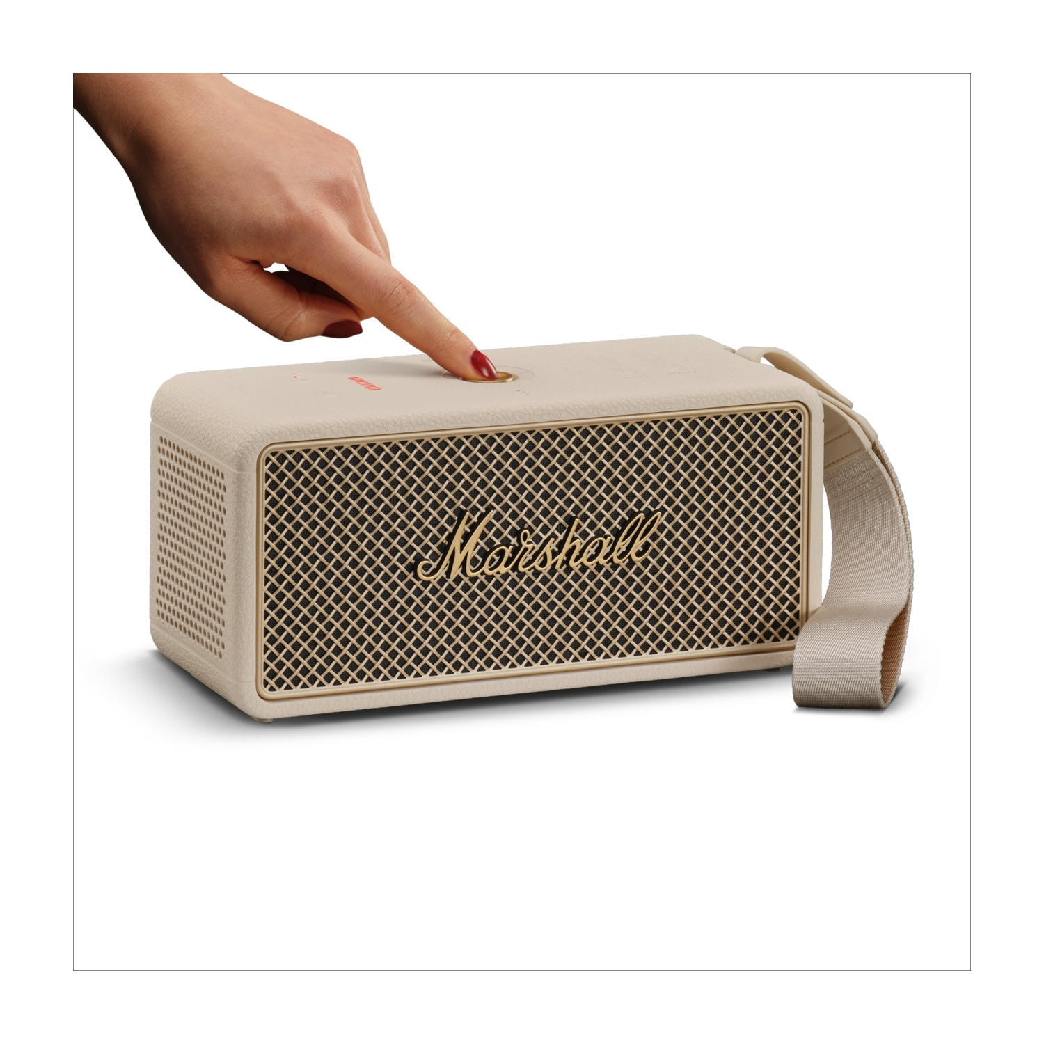 Una mano preme il pulsante di accensione su un altoparlante Marshall color crema. L'altoparlante ha una griglia anteriore e una cinghia in tessuto.
