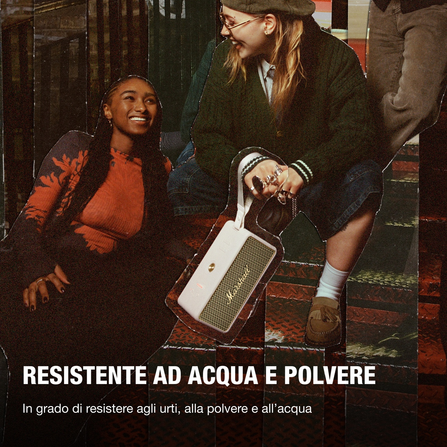 Due donne sedute su una scala, una tiene un altoparlante. Testo: RESISTENTE AD ACQUA E POLVERE (Resistente all'acqua e alla polvere).