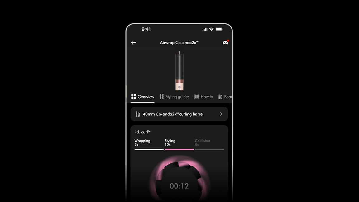Ein Smartphone-Bildschirm zeigt die Airwrap Co-anda2x Styling-Anleitung. Es zeigt einen Lockenstab mit Styling-Optionen und einem Timer.