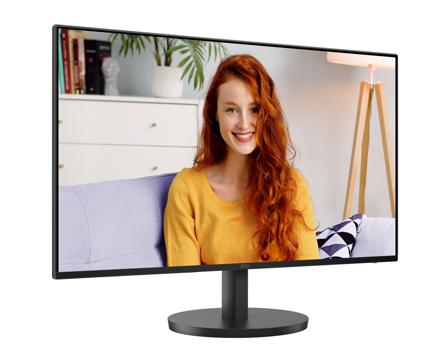 Una mujer pelirroja sonríe en un monitor. El monitor está en un soporte negro. El fondo muestra una habitación.