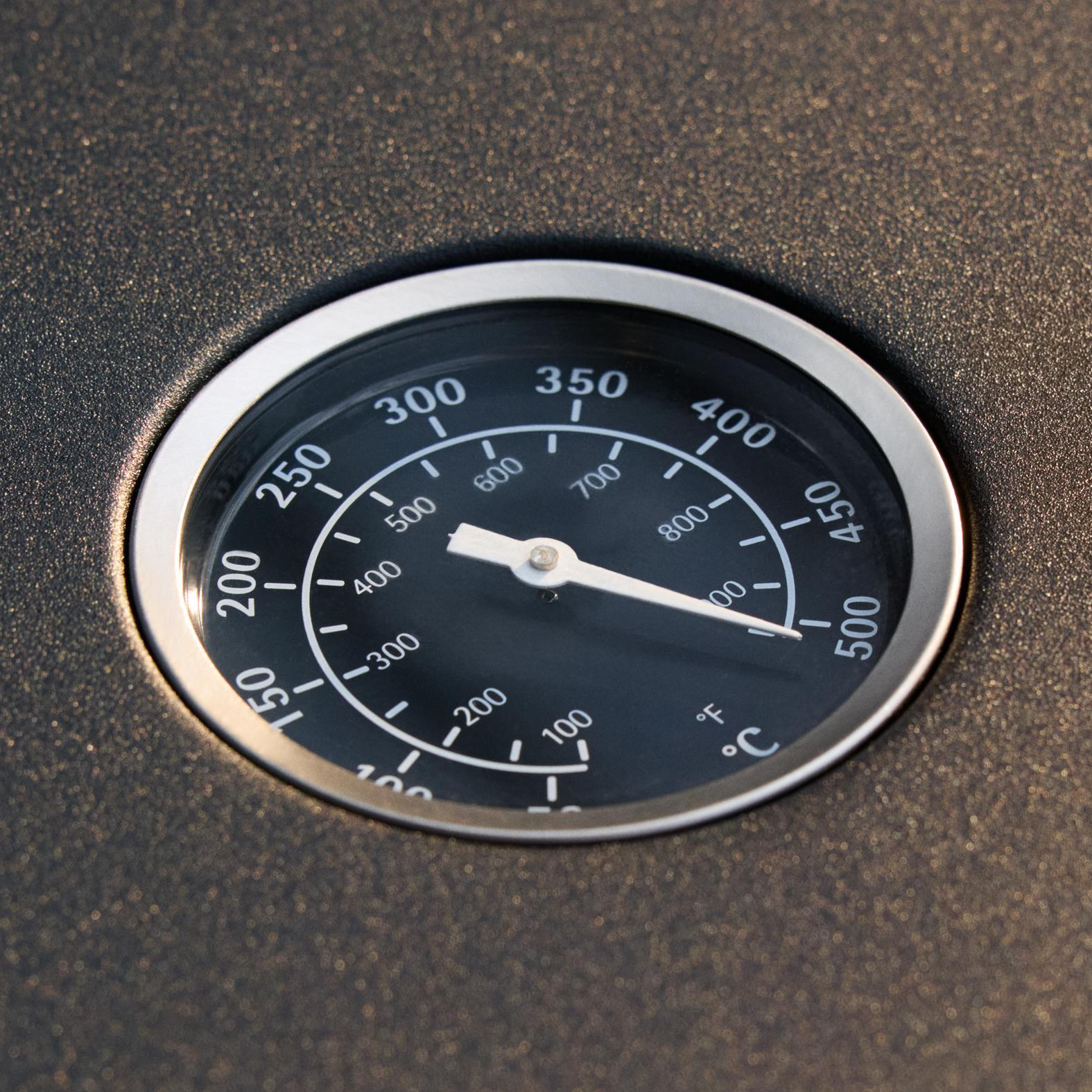 Nahaufnahme eines schwarzen Temperaturmessers mit weißer Nadel. Zahlen zeigen die Temperatur in Fahrenheit und Celsius an.