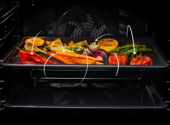 Wewnątrz piekarnika taca zawiera grillowane warzywa: czerwoną paprykę, marchew, cebulę, pomidory, szparagi i plasterki cytryny. Strzałki wskazują jedzenie.