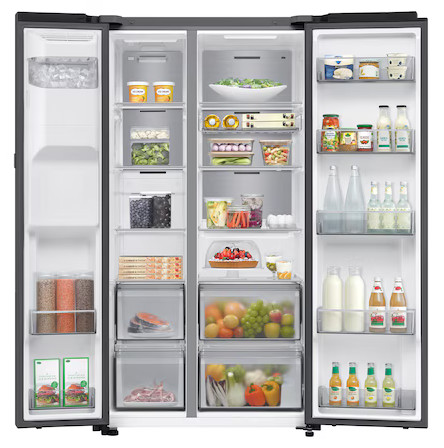 Szeroko otworzona lodówka wypełniona artykułami spożywczymi: owoce, warzywa, napoje i zapakowana żywność. Lodówka jest podzielona na sekcje.